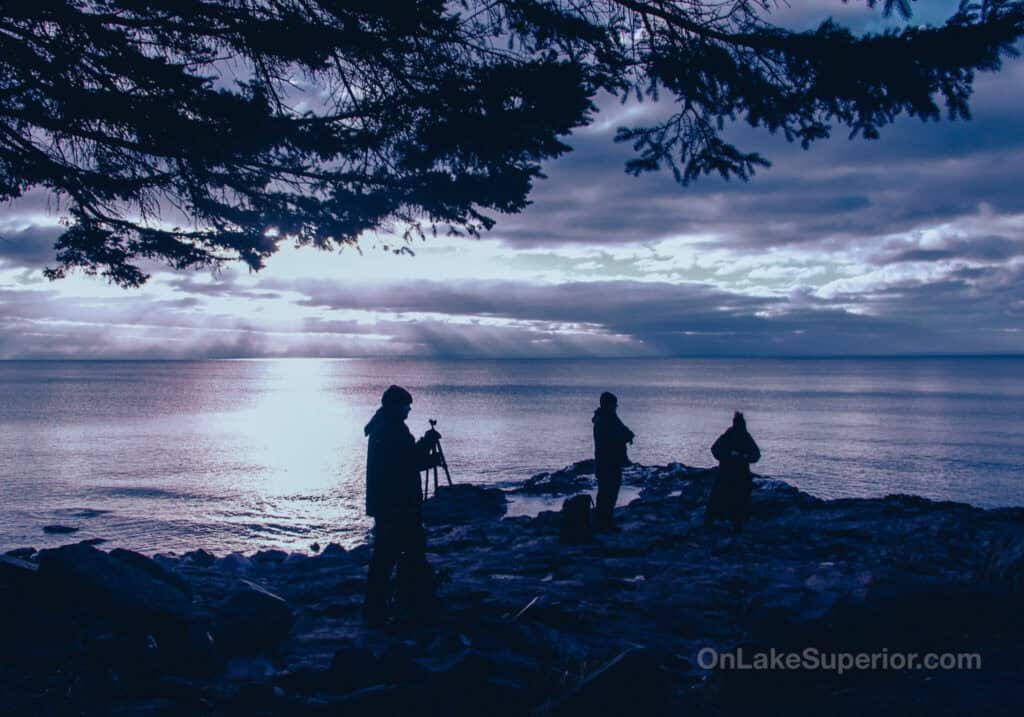 Dark silhouettes of Instructor and fellow students before sunrise on the MN north shore at Larsmont Cottages during the Lake Superior Sunrise Photography Workshop