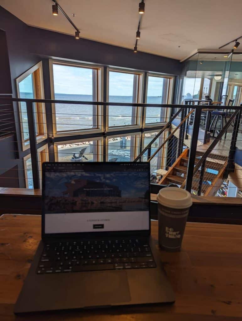 The amazing view of Lake Superior at the Sandbar coffee shop in Ashland, WI. Photograph shows coffee and laptop in foreground, with lake view in background.