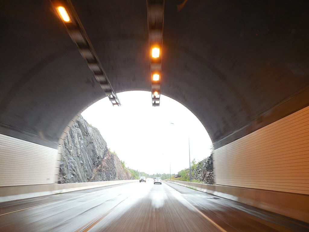 A view from a vehicle driving north as it is about to exit the Silver Cliff Creek Tunnel.