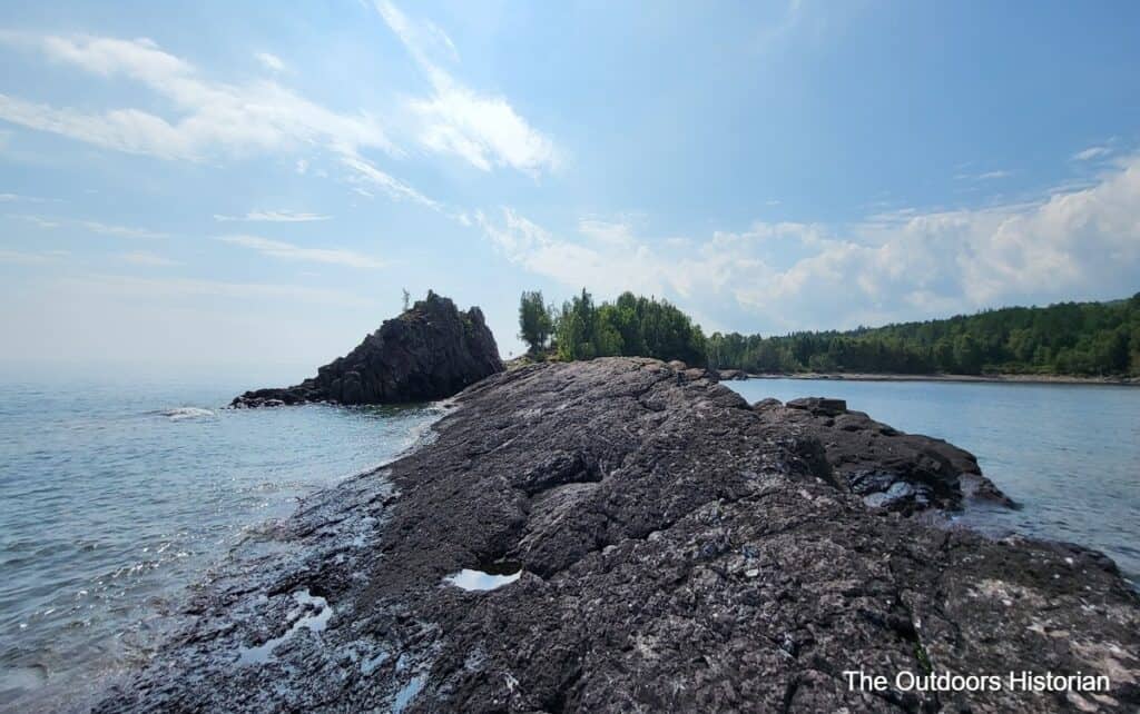 A view from the narrow, rocky point in Lake Superior, looking back the the Sugarloaf rock formation.